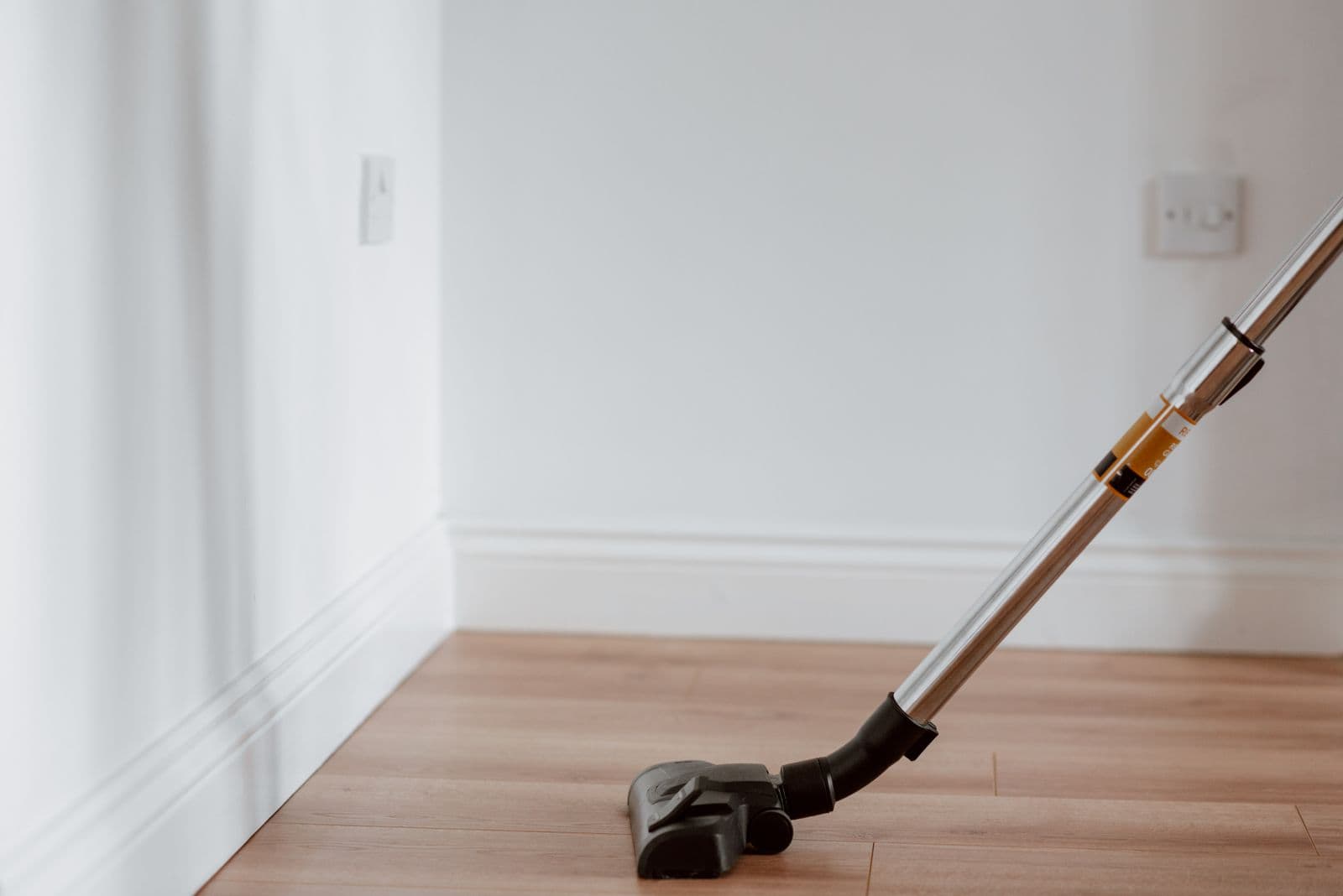 A vacuum cleaning a wooden floor in a bright home