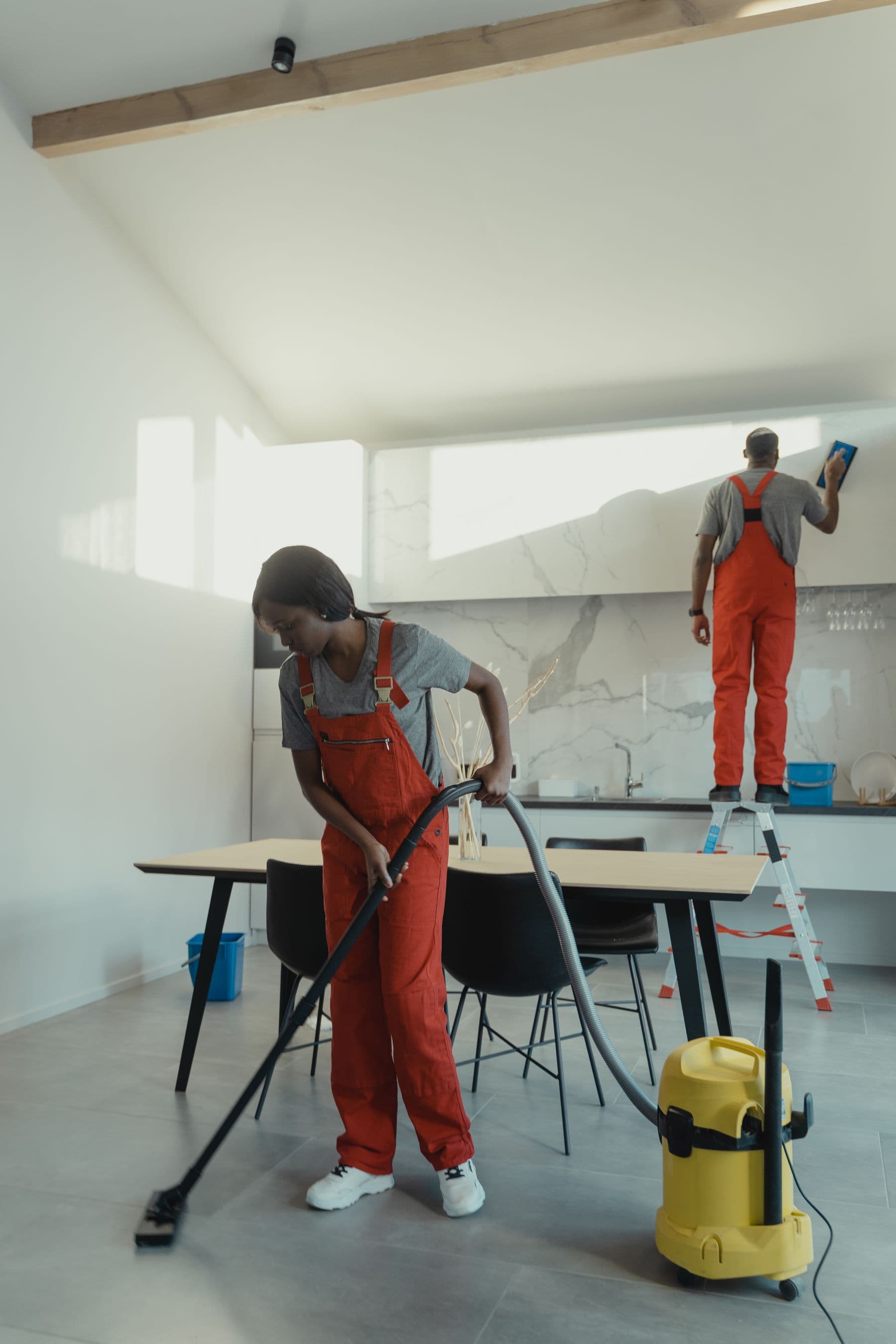 A professional cleaning team working through a modern kitchen